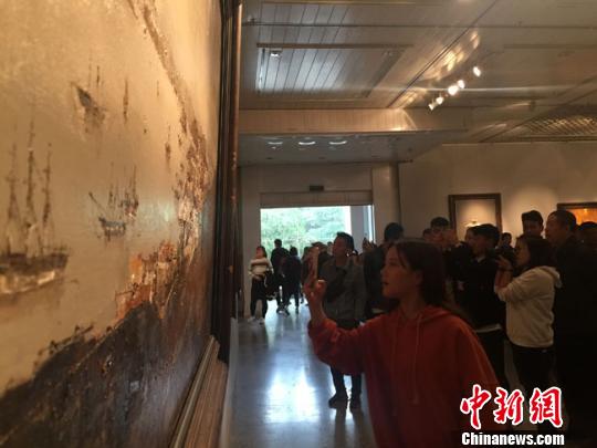 图为观众通过画展认真品读波澜壮阔的海上丝绸之路繁忙商贸。　冯志军 摄